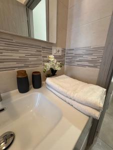a bathroom with a sink and a vase of flowers at Great Sweet Home in Strambino +17 photos