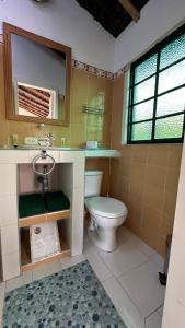 a bathroom with a toilet and a sink and a mirror at Antara House in Guasca