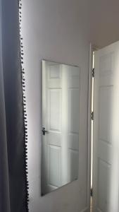 a mirror in a room with a white door at Studio Luxe on Chudleigh D in London +1 photo
