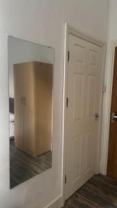 a mirror on a wall next to a door at Studio Luxe on Chudleigh D in London