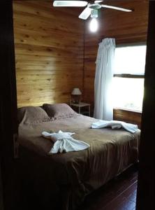 a bedroom with a bed with a wooden wall at Mi CASA in Sierra de los Padres +30 photos
