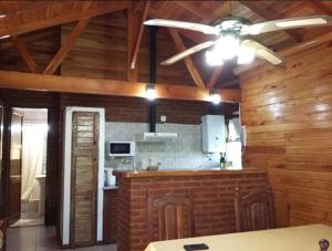 a kitchen with wooden walls and a ceiling fan at Mi CASA in Sierra de los Padres