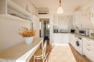 a kitchen with white cabinets and a table with chairs at Golden Tiara Apartment in Barbati