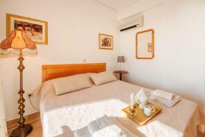 a bedroom with a bed with a lamp and a tray at Golden Tiara Apartment in Barbati