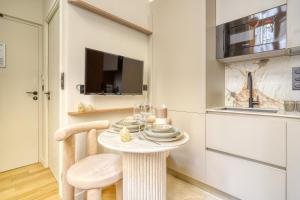 a dining room with a table and a tv at Paris La Belle - Lafayette in Paris +226 photos