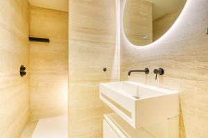 a bathroom with a white sink and a mirror at Paris La Belle - Lafayette in Paris