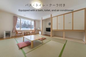 a living room with a table and a table at Shiretoko Village in Shari