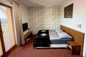 a small bedroom with a bed and a window at Apartmán Mountain View - Tatragolf C in Veľká Lomnica +22 photos