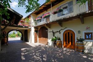 a building with flowers on the balconies and a street at Fischerhof Agriturismo in Cornaiano