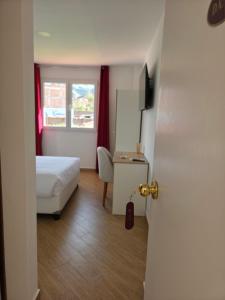 a bedroom with a bed and a desk and a window at Villa Arcadia Hotel & Eventos Cusco in Cusco