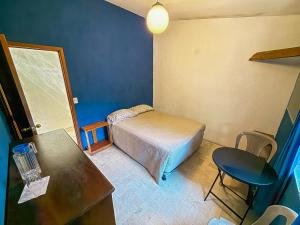 a small bedroom with a bed and a table and chair at Hotel del Bosque in Guatemala