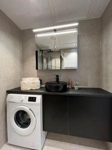 a kitchen with a washing machine and a sink at Affordable Luxury Apt - Hotel Vibe - Heart of Voss in Vossevangen