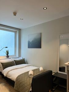 a bedroom with a large bed and a window at Affordable Luxury Apt - Hotel Vibe - Heart of Voss in Vossevangen