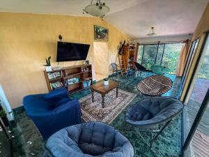 a living room with blue chairs and a tv at Hotel del Bosque in Guatemala