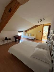 a bedroom with a large white bed in a attic at La Fermette Champenoise in Jonquery