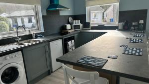 a kitchen with a sink and a washing machine at 3 bedroom cottage in Lamlash +4 photos