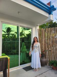 a woman in a white dress standing in front of a window at Little Zabina Inn in San Juan