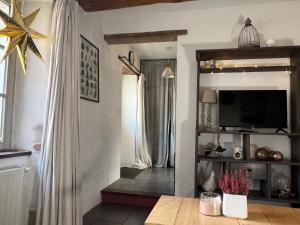 a living room with a television and a table at A L’Abri Du Loup in Roquefort-sur-Garonne