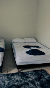 a bed in a bedroom with two pillows on it at Pousada Bem estar in Divinópolis +7 photos