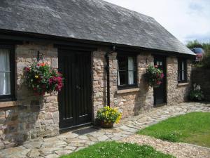 an old stone house with flowers on the door at The Long Barn nr Huntsham in Tiverton