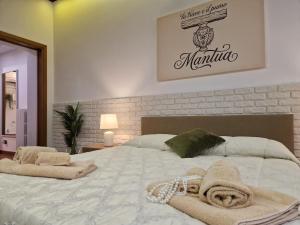 a bedroom with a large bed with towels on it at La Trave e Il Pumo Mantua in Mantova