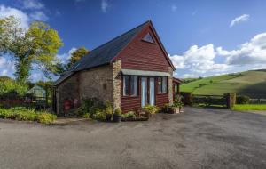 a small red house with a black roof at Putham Barn Cutcombe in Wheddon Cross