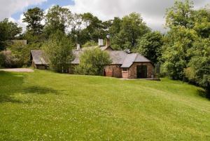 an old house on a hill with a green field at May Cottage nr Huntsham in Tiverton