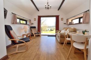 a living room with a couch and a table and chairs at May Cottage nr Huntsham in Tiverton