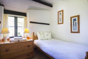 a bedroom with two beds and two lamps and a window at May Cottage nr Huntsham in Tiverton