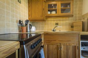a kitchen with a sink and a stove top oven at May Cottage nr Huntsham in Tiverton +13 photos