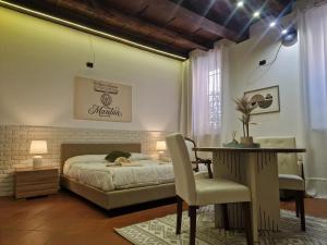 a bedroom with a bed and a table and a chair at La Trave e Il Pumo Mantua in Mantova