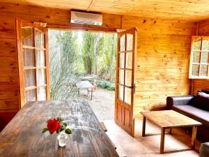 a wooden room with a table with a flower on it at Increíble cabaña de montaña in Potrerillos