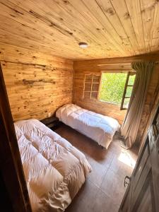 a bedroom with two beds in a log cabin at Increíble cabaña de montaña in Potrerillos