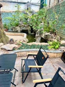 two chairs and a table in front of a pond at Khế Homestay Phố Cổ Ninh Bình in Ninh Binh