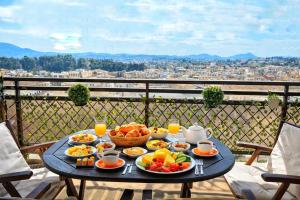 a table with food on it with a view of a city at Corfu SKYLINE RESIDENT 360 in Corfu