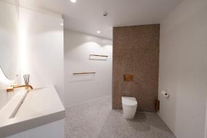 a white bathroom with a toilet and a sink at 19th Avenue on the Beach in Gold Coast