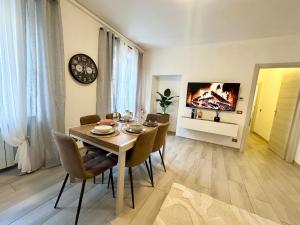 a dining room with a table and chairs and a tv at Casa Loren in Novara