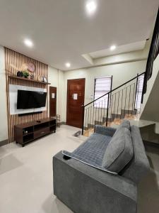 a living room with a couch and a flat screen tv at Cozy Cove in Baclayon