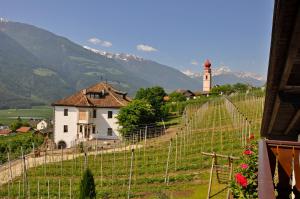 a village with a church and a lighthouse on a hill at Klostergut in Kastelbell-Tschars