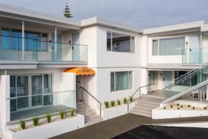 an exterior view of a white building with an orange umbrella at The Sea Breeze in Timaru