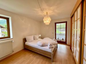 a bedroom with a bed and a chandelier at Ferienhaus Kenzenkopf in Halblech