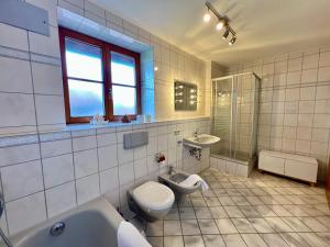 a bathroom with a toilet and a tub and a sink at Ferienhaus Kenzenkopf in Halblech +11 photos