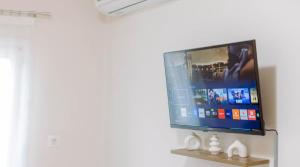 a flat screen tv hanging on a wall at The Calm City Escape in Heraklio