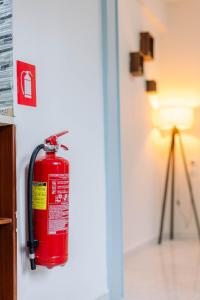 a red fire hydrant on a wall next to a lamp at The Calm City Escape in Heraklio