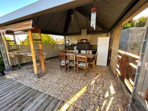 a screened in porch with a table and a refrigerator at Villa Annaga in Saint-Paul