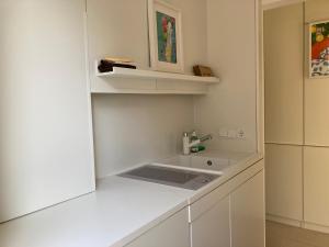 a white kitchen with a sink and a cabinet at SweetSuites 40A Lavendelhaus in Mühlhausen +61 photos