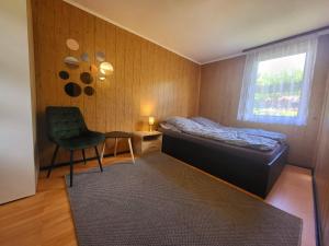 a small bedroom with a bed and a chair at Domek Dębowy in Brzozie