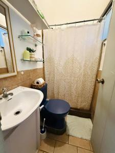 a bathroom with a blue toilet and a sink at Quepos Prime in Quepos +17 photos