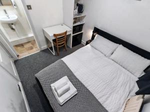 a bedroom with a bed and a desk and a sink at Small Compact Self Contained Studio Flat in Oxford