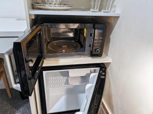 a microwave oven sitting on top of a kitchen counter at Small Compact Self Contained Studio Flat in Oxford